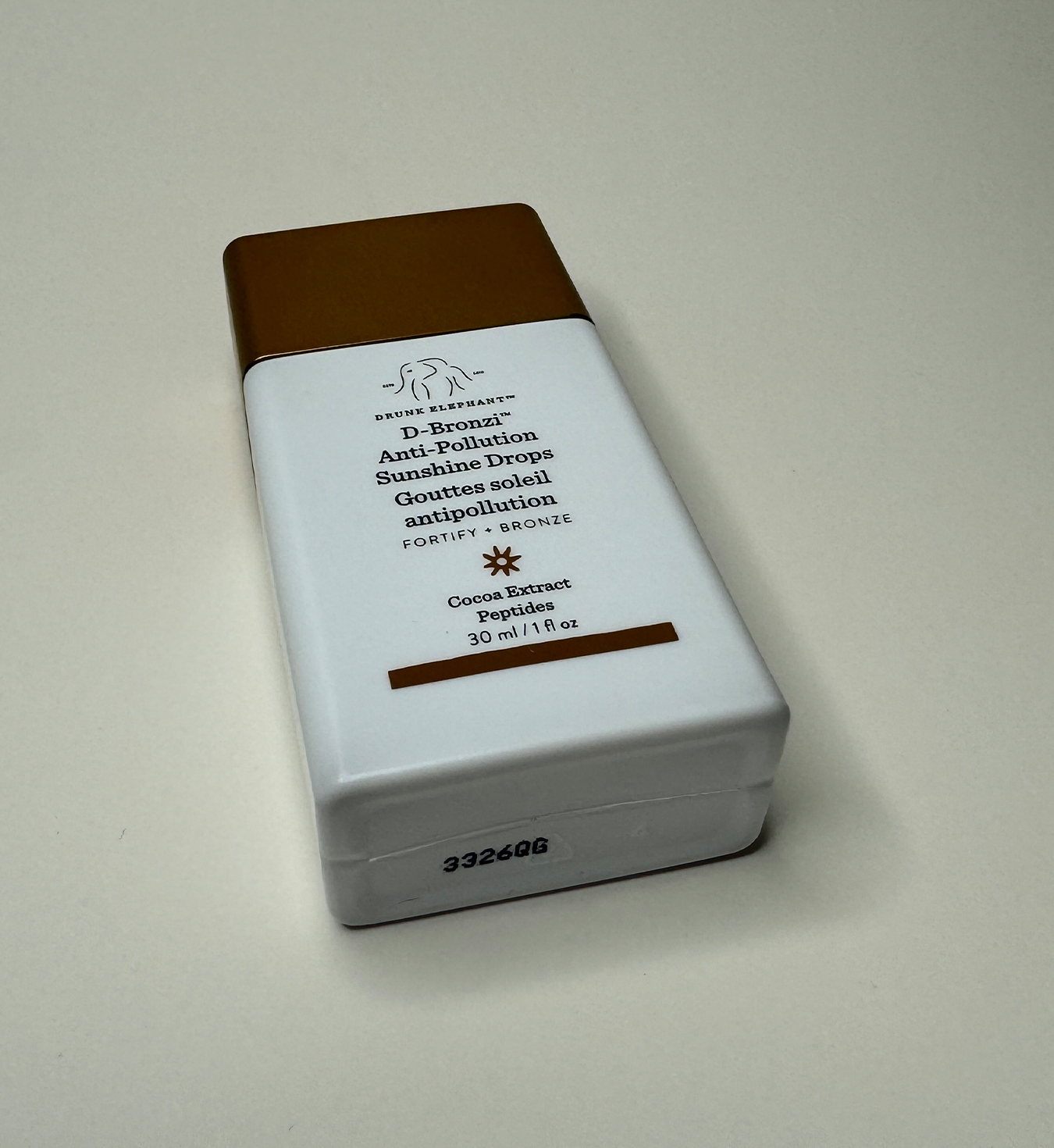 Image of the bottom and front of Drunk Elephant bronzing drops